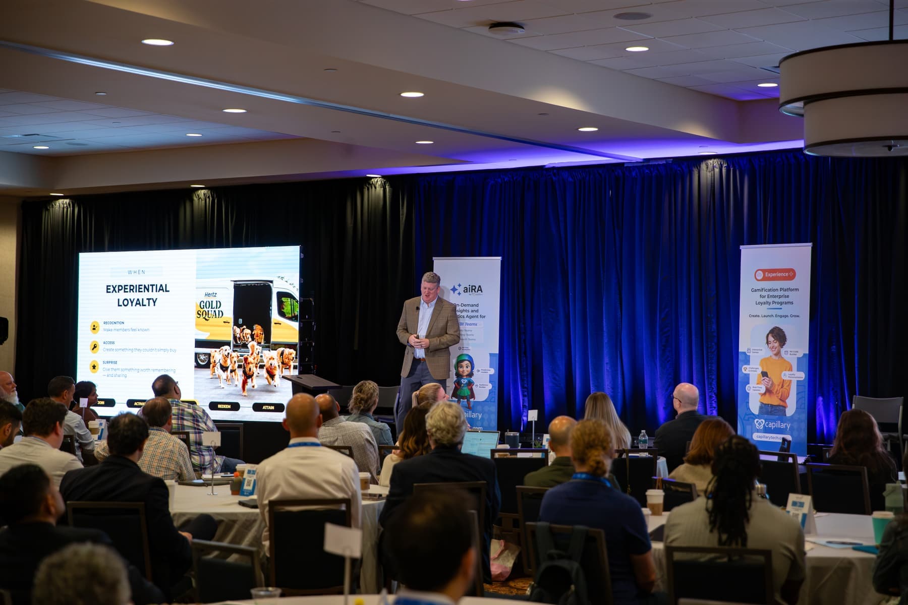A Hertz speaker presenting a slide on experiential loyalty to a full room