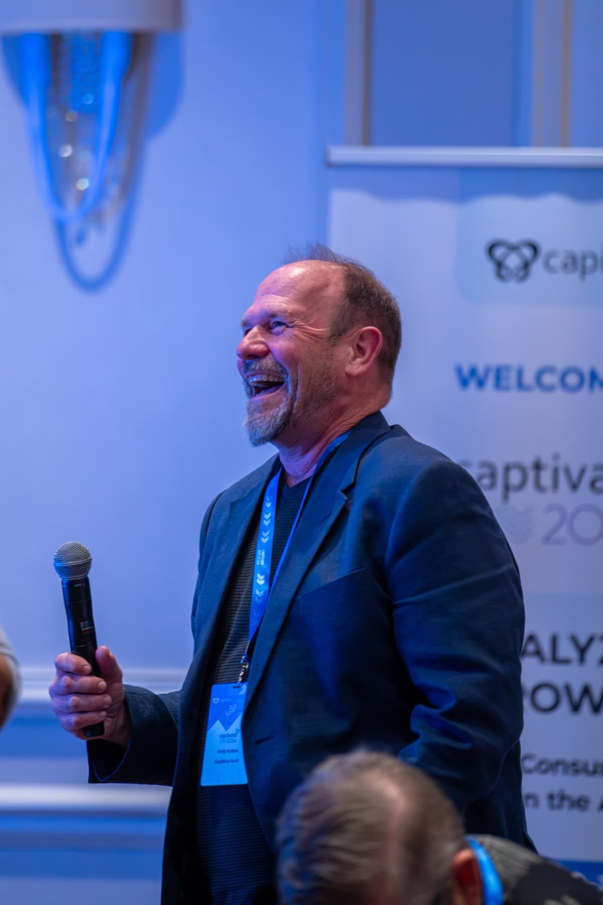 An attendee laughing while holding a microphone